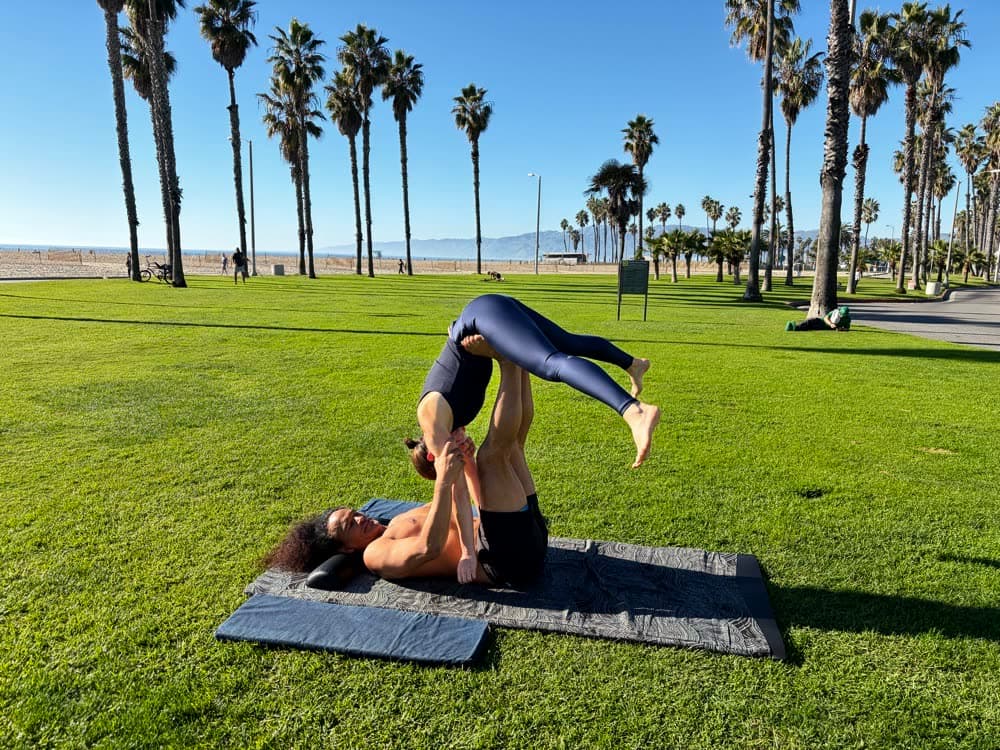 A flying acro pose by the beach