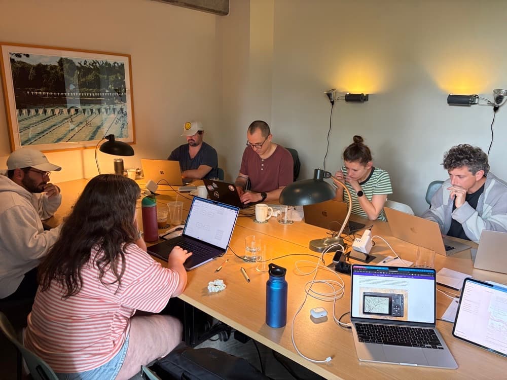 The team working together at the office table under warm wall lamps